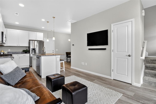 19629 W 93rd Dr Unit C, Arvada, CO 80007 - living area featuring light wood finished floors, stairway, and recessed lighting