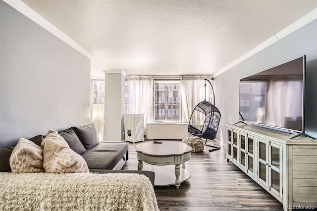 living room with ornamental molding, a textured ceiling, and wood finished floors