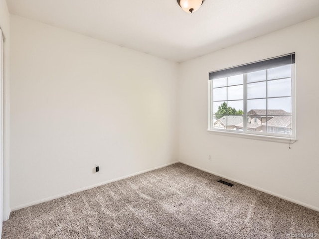 carpeted spare room featuring baseboards
