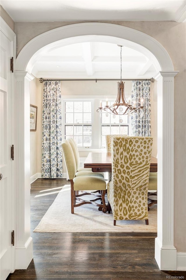 dining space with dark wood-type flooring, a chandelier, beamed ceiling, and coffered ceiling