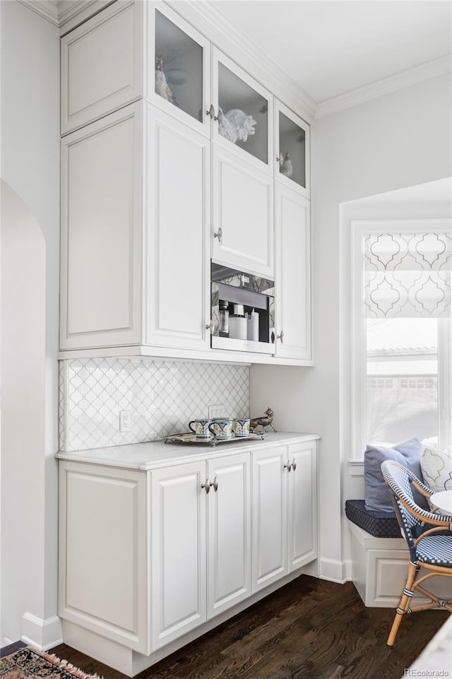 bar with ornamental molding, backsplash, white cabinetry, and dark hardwood / wood-style flooring