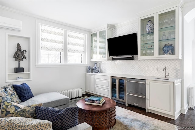 living room featuring radiator, dark hardwood / wood-style flooring, wine cooler, a wall unit AC, and wet bar