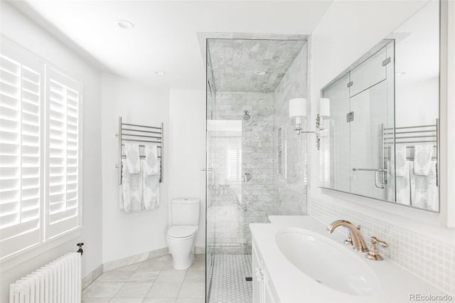 bathroom with toilet, radiator, an enclosed shower, and vanity