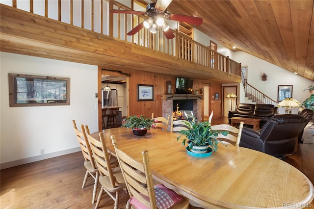 688 Obsidian Dr, Florissant, CO 80816 - dining area with a brick fireplace, ceiling fan, stairway, high vaulted ceiling, and wood finished floors