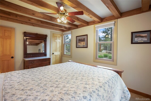 688 Obsidian Dr, Florissant, CO 80816 - bedroom featuring multiple windows, beam ceiling, baseboards, and a ceiling fan