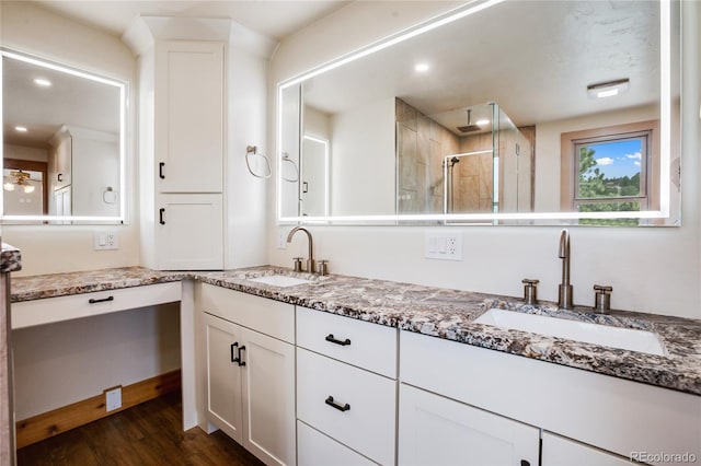 688 Obsidian Dr, Florissant, CO 80816 - full bath with double vanity, a shower stall, wood finished floors, and recessed lighting