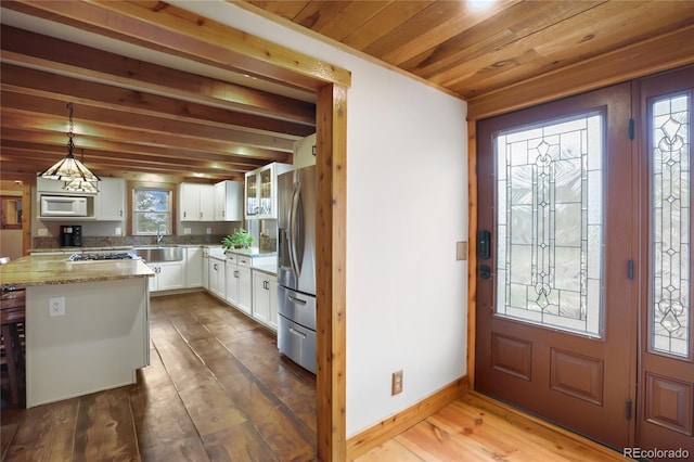 688 Obsidian Dr, Florissant, CO 80816 - kitchen featuring white microwave, stainless steel fridge, white cabinets, wood finished floors, and a sink