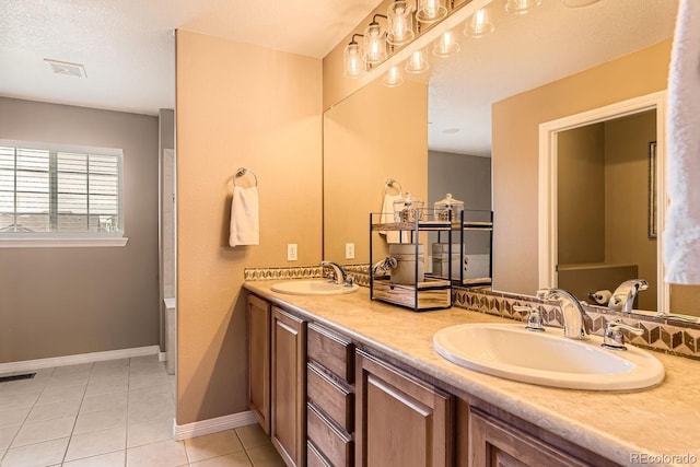 full bathroom featuring double vanity, tile patterned flooring, visible vents, and a sink