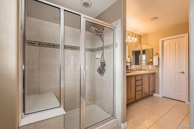 full bath with a stall shower, vanity, and tile patterned floors