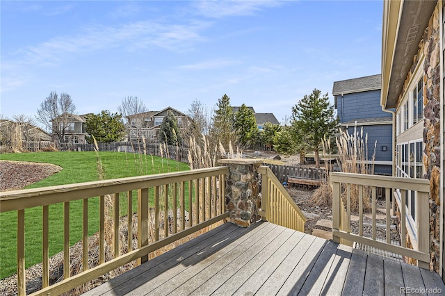 deck featuring a residential view, fence, and a lawn