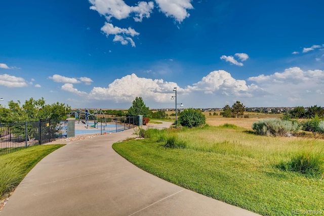 view of property's community with a swimming pool and fence