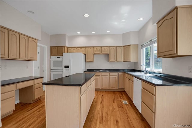 kitchen featuring light brown cabinets, white appliances, light wood finished floors, a sink, and recessed lighting