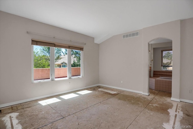 spare room with arched walkways and baseboards