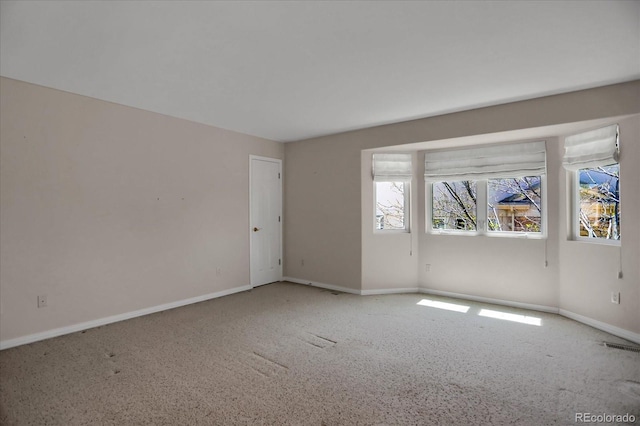 spare room with baseboards and carpet