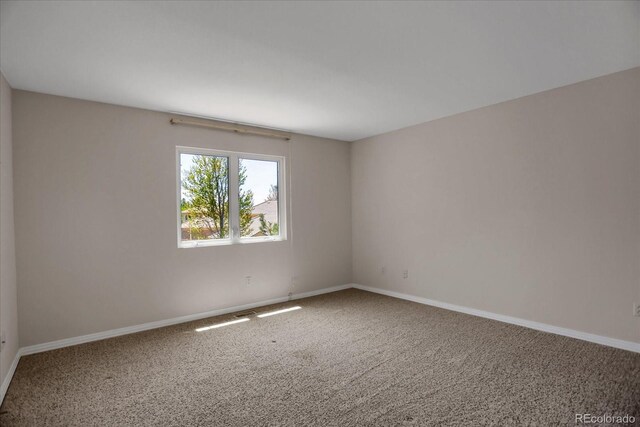 unfurnished room featuring carpet floors and baseboards