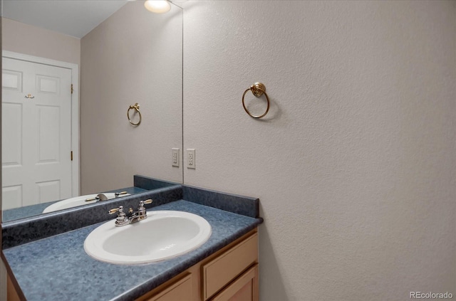 bathroom with vanity and a textured wall