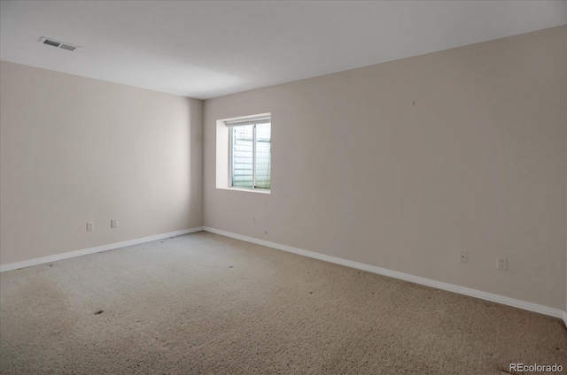 carpeted empty room featuring baseboards