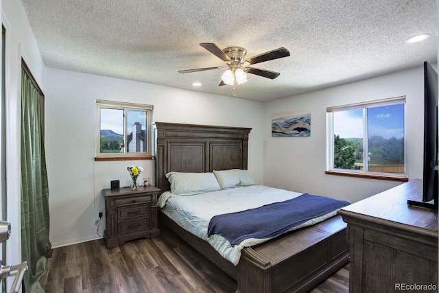 bedroom with multiple windows, dark wood-type flooring, a textured ceiling, a ceiling fan, and recessed lighting