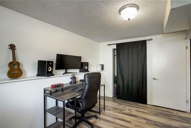 office with a textured ceiling and wood finished floors