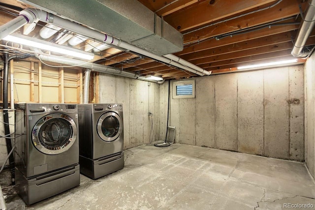 unfinished below grade area featuring washing machine and clothes dryer