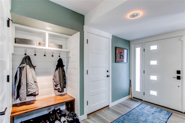 mudroom featuring a wealth of natural light, baseboards, and light wood-style flooring