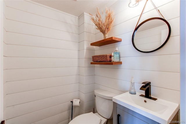 half bath featuring toilet and vanity