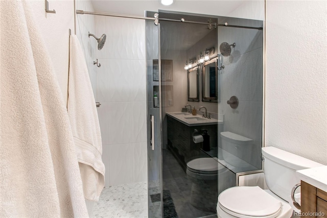 full bathroom featuring toilet, vanity, walk in shower, and a textured wall