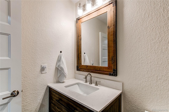 bathroom featuring vanity and a textured wall