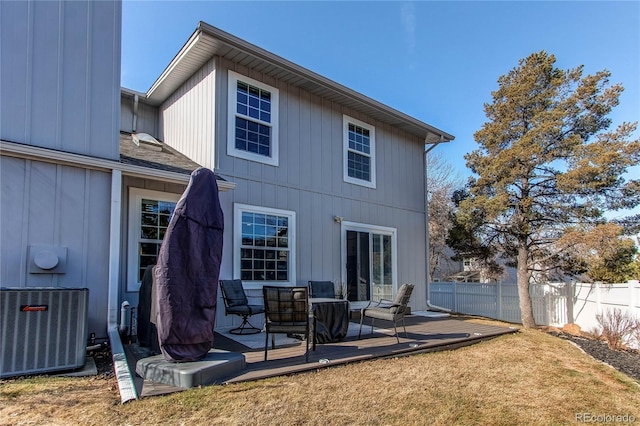 rear view of property with cooling unit, a wooden deck, and fence