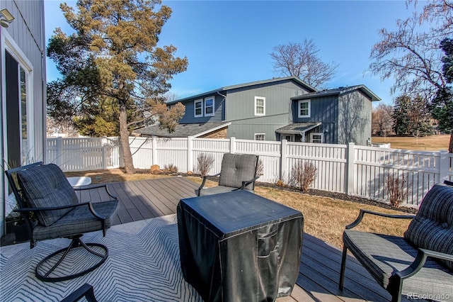 wooden terrace with a fenced backyard