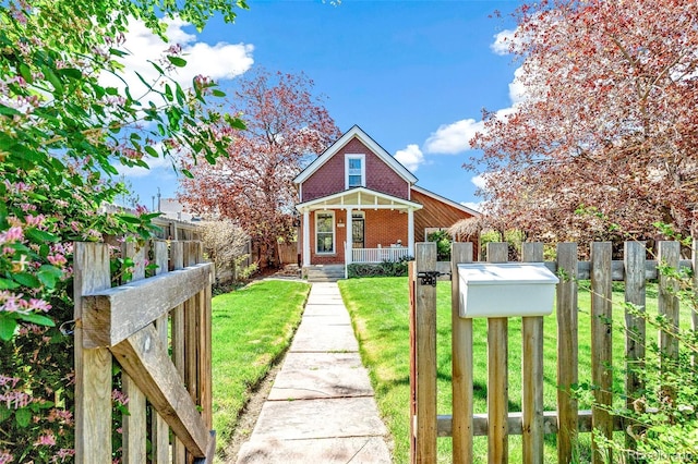 bungalow-style home featuring covered porch, a front yard, fence private yard, and brick siding