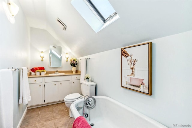 bathroom featuring a freestanding bath, vanity, toilet, visible vents, and lofted ceiling with skylight