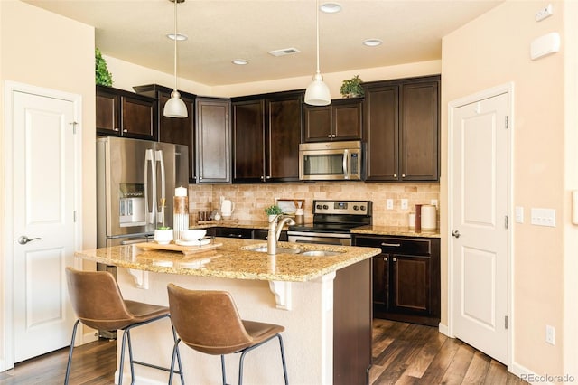 5562 W 72nd Pl, Westminster, CO 80003 - kitchen featuring appliances with stainless steel finishes, dark wood-style floors, light stone counters, tasteful backsplash, and recessed lighting