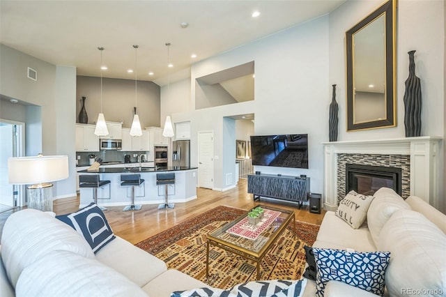 1261 W 170th Ave, Broomfield, CO 80023 - living area featuring high vaulted ceiling, light wood-style flooring, a fireplace, and recessed lighting