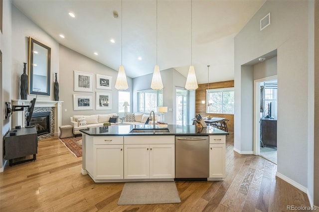 1261 W 170th Ave, Broomfield, CO 80023 - kitchen with stainless steel dishwasher, dark countertops, white cabinets, light wood-type flooring, and open floor plan