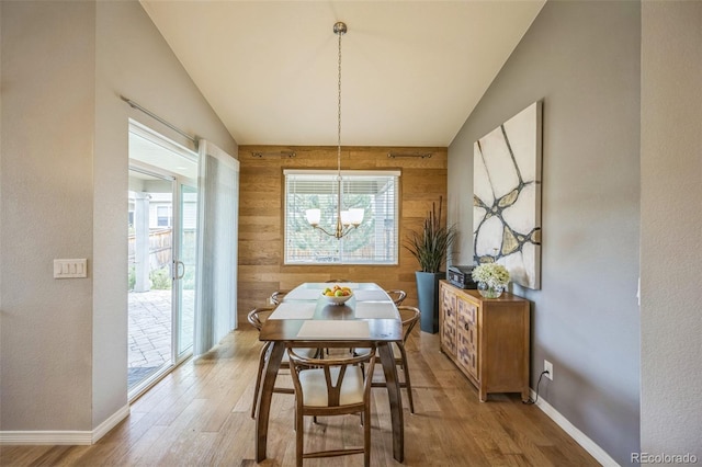 1261 W 170th Ave, Broomfield, CO 80023 - dining room with a chandelier, wooden walls, wood finished floors, and lofted ceiling