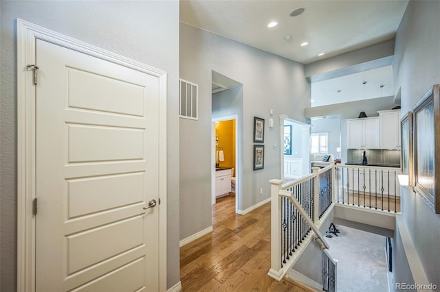 1261 W 170th Ave, Broomfield, CO 80023 - hallway featuring an upstairs landing, light wood-style floors, a towering ceiling, and recessed lighting