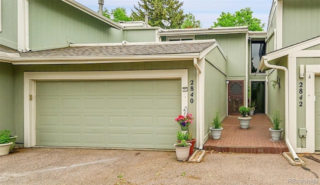 2840 S Kenton Ct, Aurora, CO 80014 - view of exterior entry with a shingled roof, asphalt driveway, and a garage