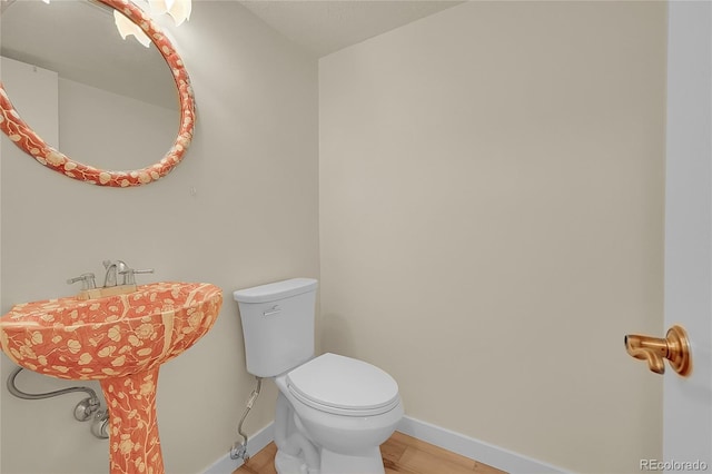 2840 S Kenton Ct, Aurora, CO 80014 - half bathroom featuring wood finished floors, toilet, and baseboards