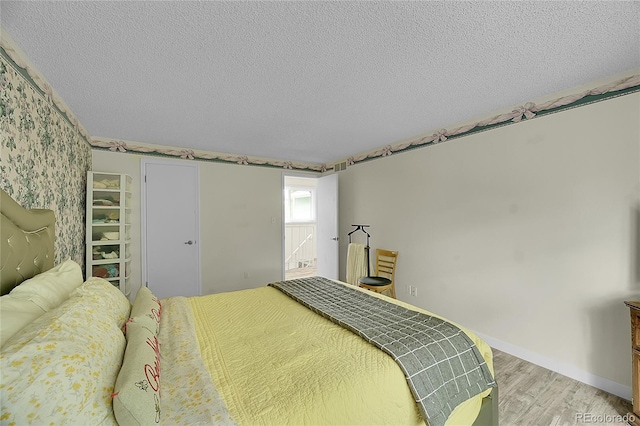 2840 S Kenton Ct, Aurora, CO 80014 - bedroom featuring light wood-style flooring, a textured ceiling, and baseboards