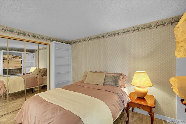 2840 S Kenton Ct, Aurora, CO 80014 - bedroom featuring wood finished floors, a closet, and wallpapered walls