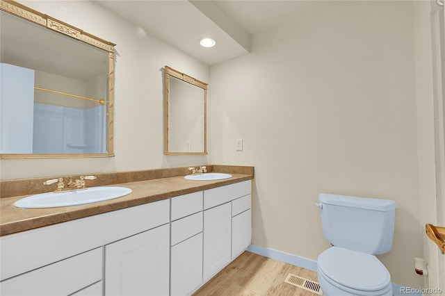 2840 S Kenton Ct, Aurora, CO 80014 - bathroom with double vanity, wood finished floors, a shower, and recessed lighting