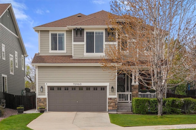 15960 W 62nd Dr, Arvada, CO 80403 - view of front facade featuring concrete driveway, a garage, a shingled roof, and stone siding