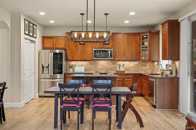 15960 W 62nd Dr, Arvada, CO 80403 - kitchen featuring brown cabinetry, stainless steel appliances, light wood-type flooring, and a sink