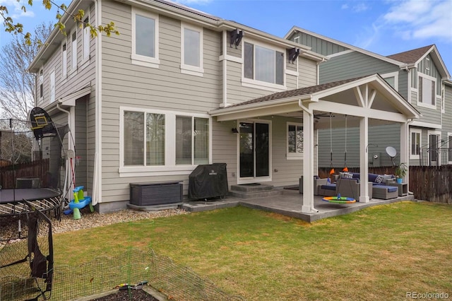 15960 W 62nd Dr, Arvada, CO 80403 - back of property featuring a trampoline, outdoor lounge area, fence, a lawn, and a patio area