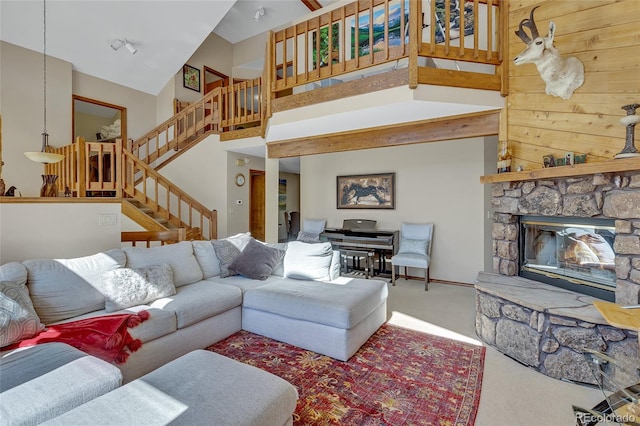 living room with carpet, high vaulted ceiling, and a stone fireplace