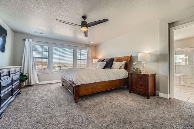 carpeted bedroom featuring a textured ceiling, a ceiling fan, connected bathroom, and baseboards