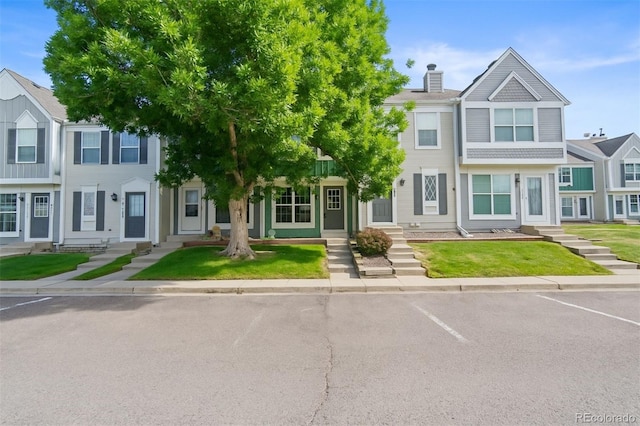10814 Bayfield Way, Parker, CO 80138 - townhome / multi-family property featuring entry steps, a chimney, uncovered parking, and a front lawn