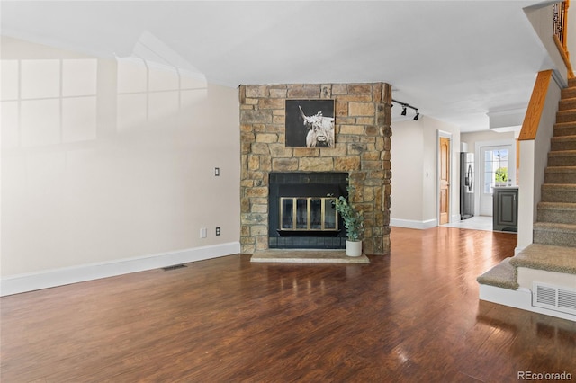 10814 Bayfield Way, Parker, CO 80138 - unfurnished living room featuring stairs, wood finished floors, and a stone fireplace