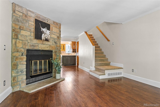 10814 Bayfield Way, Parker, CO 80138 - unfurnished living room featuring ornamental molding, a fireplace, wood finished floors, and stairway